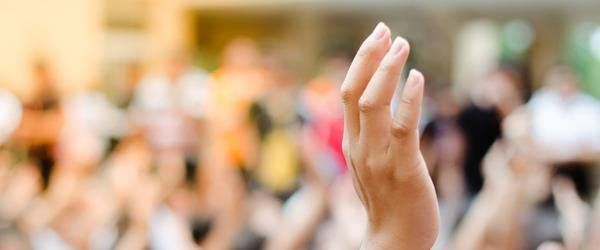 Raised hand - crowd blurred in the background